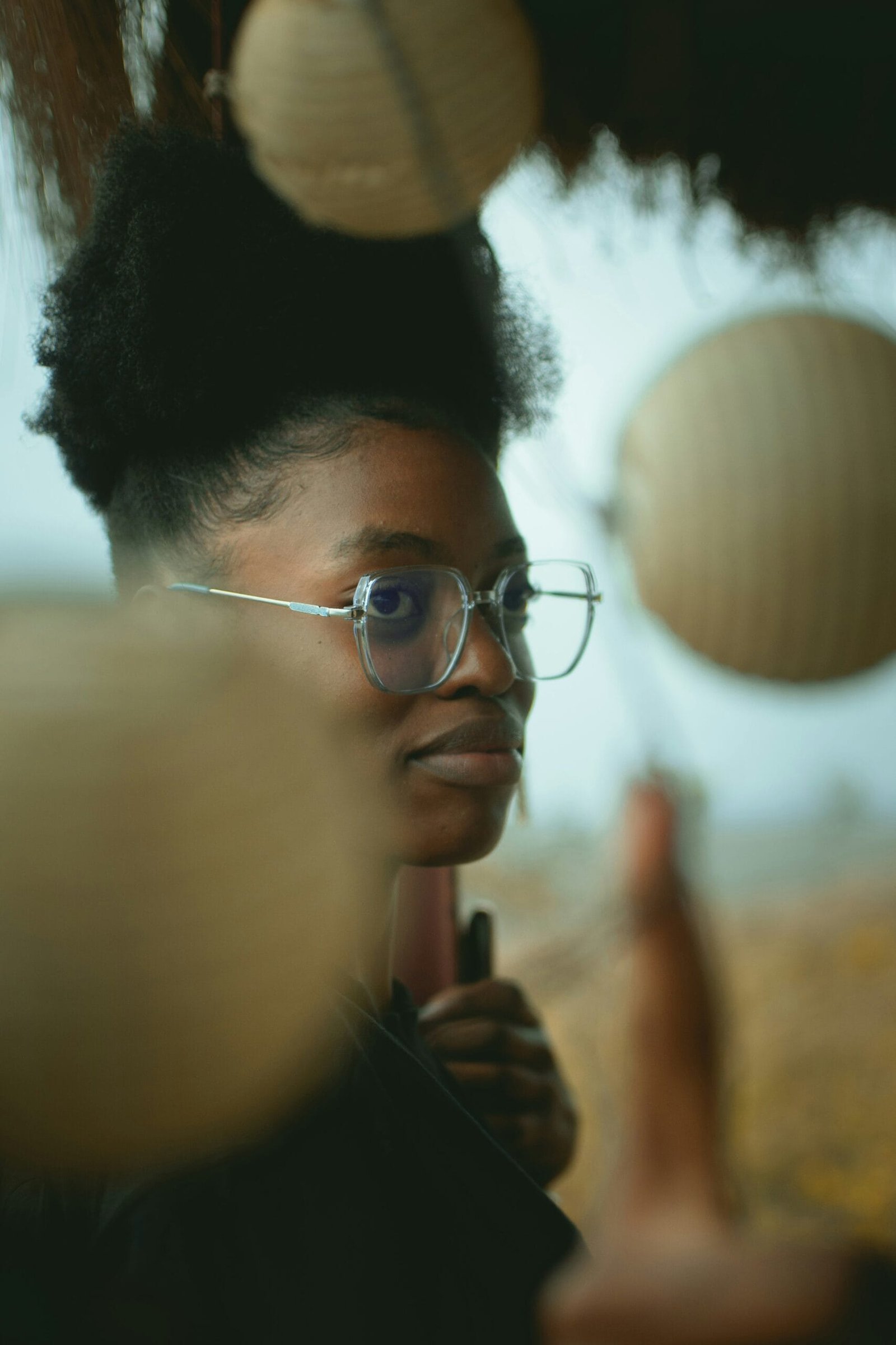 A woman wearing glasses looking at a mirror