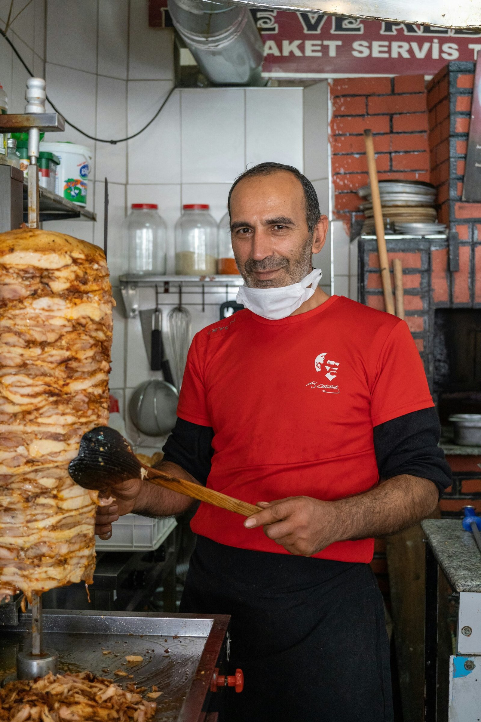 a man in a red shirt is holding a large piece of meat